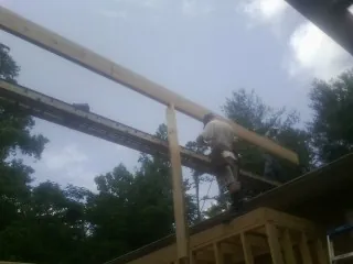 Carpenter setting a ridge beam over a new addition frame — Ice Dam Removal by Roofing Brothers in Peach Bottom
