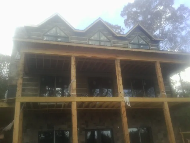 Dormers and porch framing on a large log home under construction — Roof Coating work by our crew in Peach Bottom