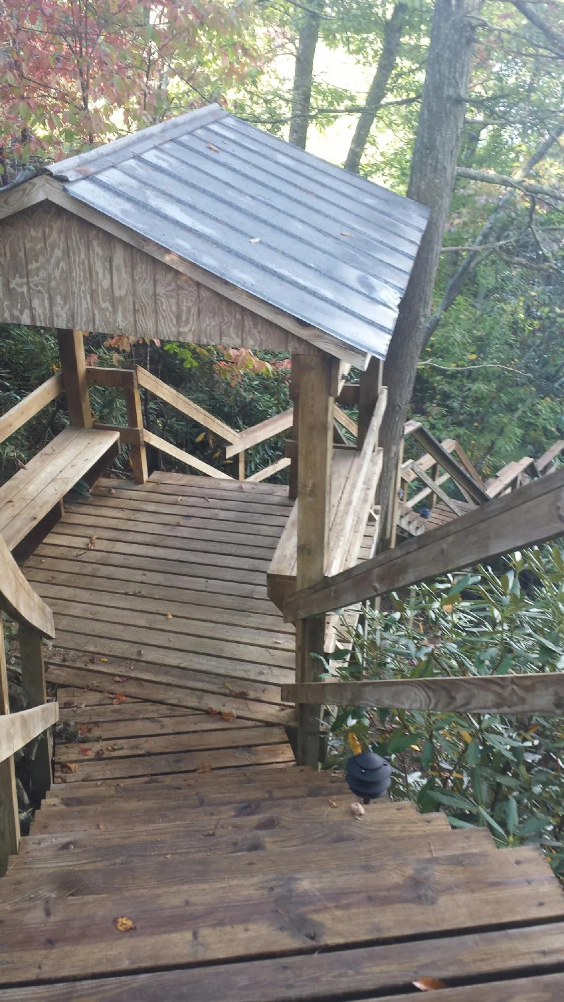 Metal roofed shelter over wooden steps on a wooded walkway — Skylight Repair & Installation work by our crew in Peach Bottom