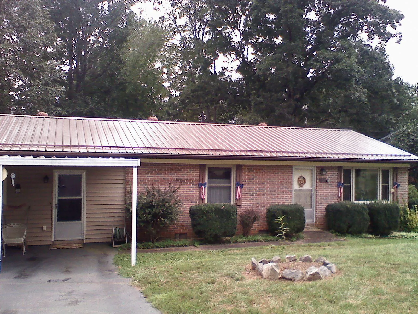 Bronze metal roof and carport on a brick ranch home — Roof Repair work by our crew in Peach Bottom